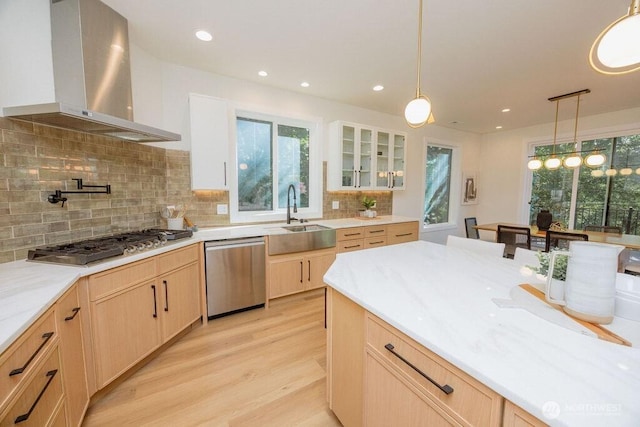 14737 56th Ave S, Tukwila, WA 98168 - kitchen with wall chimney range hood, stainless steel appliances, light brown cabinets, light wood-style floors, and glass insert cabinets