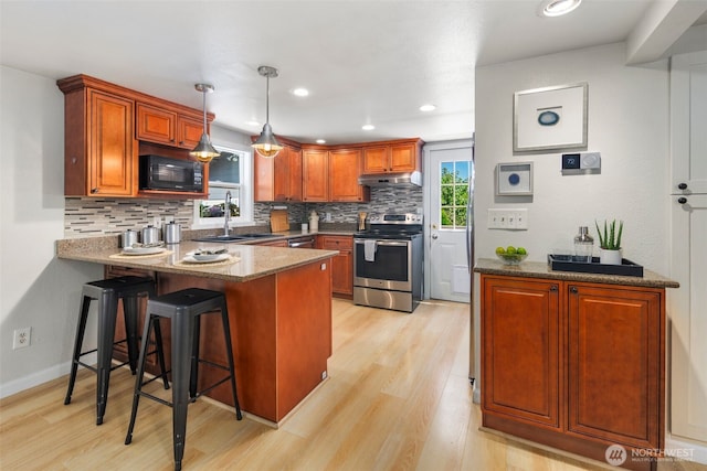 11432 11th Ave SW, Seattle, WA 98146 - kitchen featuring appliances with stainless steel finishes, a peninsula, under cabinet range hood, decorative backsplash, and recessed lighting