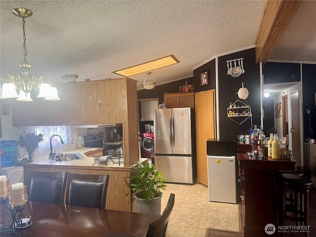 7619 156th Street Ct E Unit 9, Puyallup, WA 98375 - kitchen featuring freestanding refrigerator, a chandelier, a textured ceiling, lofted ceiling, and ornamental molding