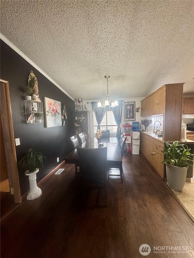 7619 156th Street Ct E Unit 9, Puyallup, WA 98375 - dining space with a textured ceiling, a chandelier, dark wood-style flooring, crown molding, and lofted ceiling