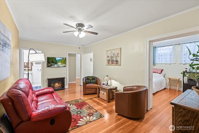 7 Harrison St Unit 5, Seattle, WA 98109 - living area featuring ceiling fan, light wood finished floors, crown molding, and a glass covered fireplace