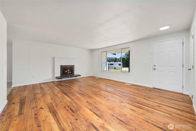 11613 63rd Street Ct E, Puyallup, WA 98372 - unfurnished living room featuring hardwood / wood-style flooring and a warm lit fireplace