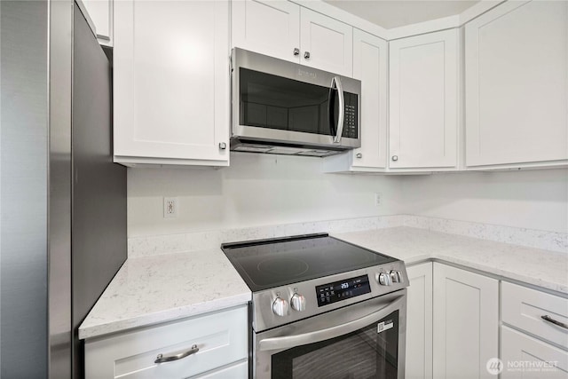 11613 63rd Street Ct E, Puyallup, WA 98372 - kitchen featuring stainless steel appliances, white cabinetry, and light stone counters