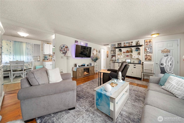 11613 63rd Street Ct E, Puyallup, WA 98372 - living area featuring light wood-type flooring, cooling unit, a textured ceiling, and a fireplace