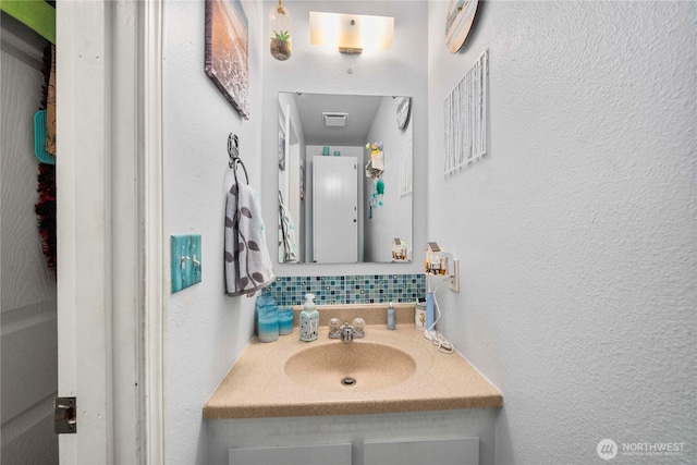 11613 63rd Street Ct E, Puyallup, WA 98372 - bathroom with vanity, decorative backsplash, and a textured wall