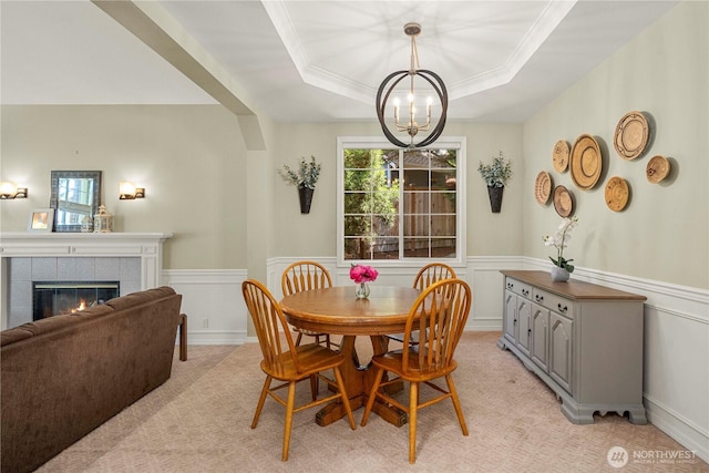 30449 103rd Ct SE, Auburn, WA 98092 - dining space with a chandelier, a wainscoted wall, a tray ceiling, a fireplace, and light carpet