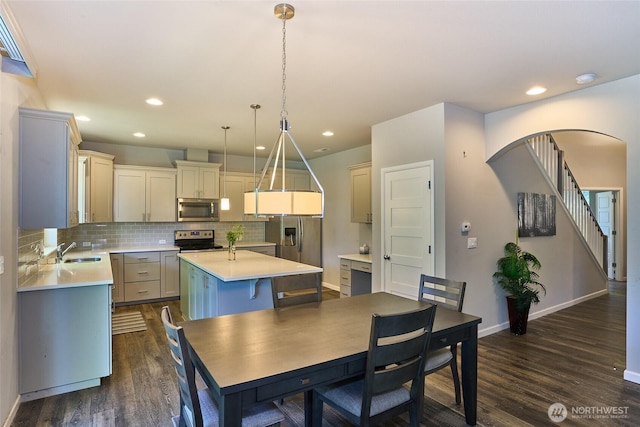 12235 SE 253rd St, Kent, WA 98030 - dining space featuring dark wood finished floors, arched walkways, and recessed lighting