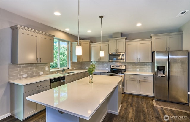 12235 SE 253rd St, Kent, WA 98030 - kitchen with stainless steel appliances, dark wood finished floors, gray cabinetry, light countertops, and a kitchen island