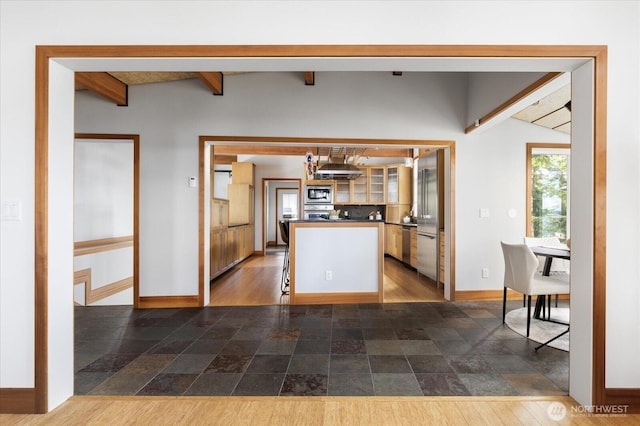 222 Rhodena Dr, Coupeville, WA 98239 - kitchen featuring appliances with stainless steel finishes, ventilation hood, beamed ceiling, dark countertops, and dark stone finish floors
