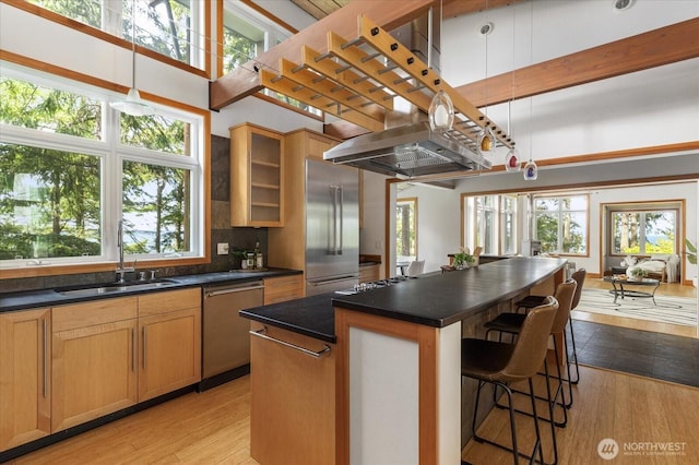 222 Rhodena Dr, Coupeville, WA 98239 - kitchen featuring appliances with stainless steel finishes, dark countertops, a kitchen bar, and a center island