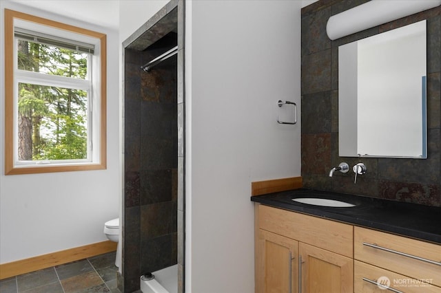 222 Rhodena Dr, Coupeville, WA 98239 - bathroom with vanity, stone finish flooring, a tile shower, and decorative backsplash