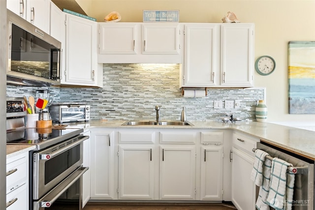 1311 Ocean Shores Blvd SW Unit 5, Ocean Shores, WA 98569 - kitchen featuring stainless steel appliances, light countertops, white cabinetry, and tasteful backsplash