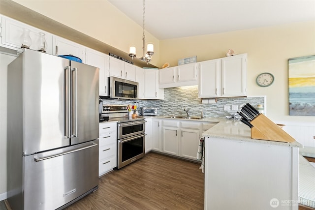 1311 Ocean Shores Blvd SW Unit 5, Ocean Shores, WA 98569 - kitchen with appliances with stainless steel finishes, a peninsula, decorative backsplash, white cabinetry, and dark wood finished floors