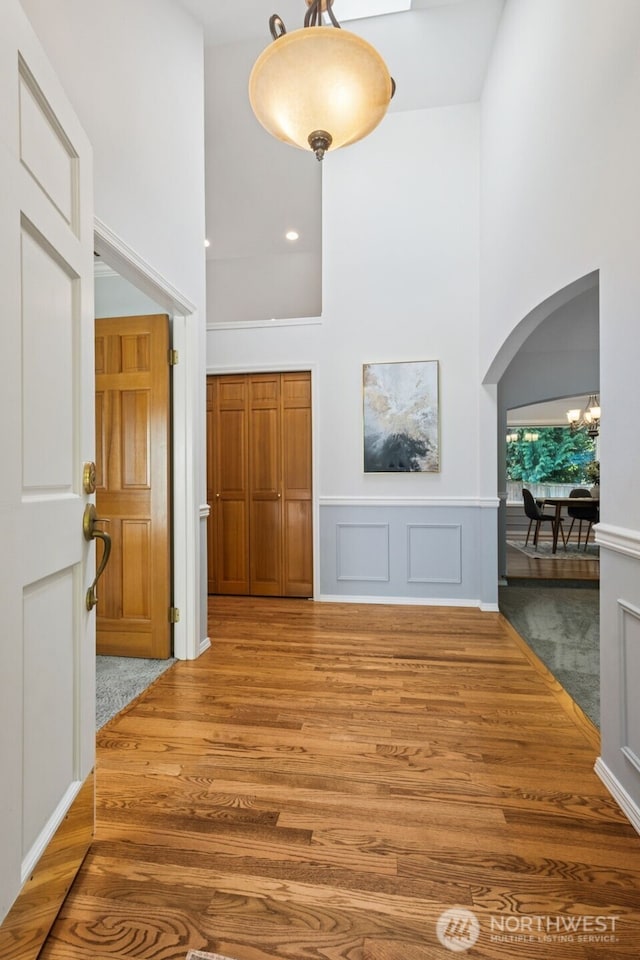 28314 180th Ave SE, Covington, WA 98042 - unfurnished living room with a high ceiling, arched walkways, wood finished floors, and a chandelier