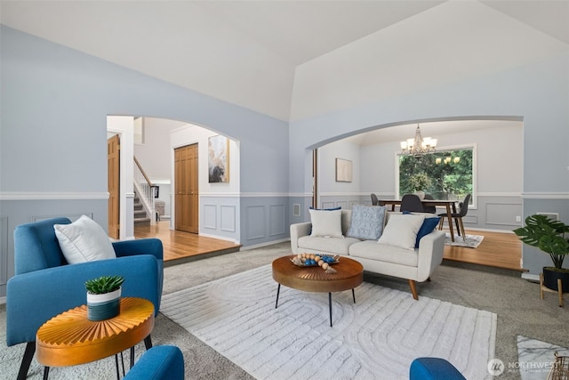 28314 180th Ave SE, Covington, WA 98042 - living room with arched walkways, a chandelier, light colored carpet, a decorative wall, and high vaulted ceiling