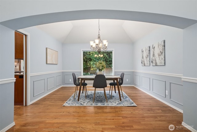 28314 180th Ave SE, Covington, WA 98042 - dining space featuring a chandelier, light wood-style flooring, wainscoting, vaulted ceiling, and a decorative wall