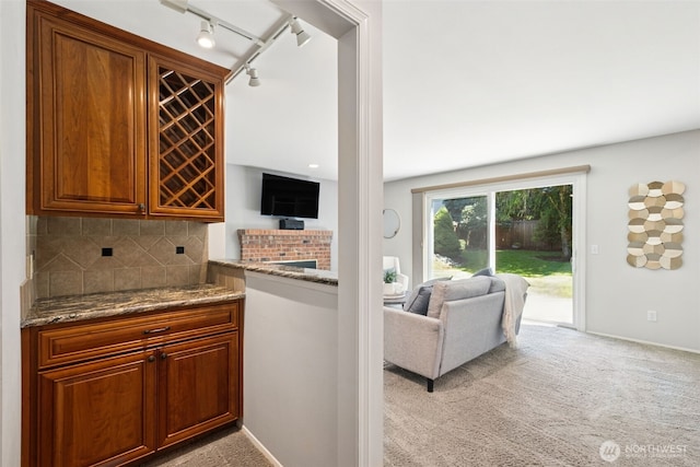 28314 180th Ave SE, Covington, WA 98042 - kitchen with light carpet, dark stone counters, decorative backsplash, rail lighting, and open floor plan