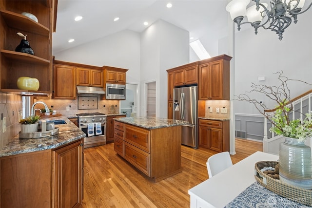 28314 180th Ave SE, Covington, WA 98042 - kitchen with appliances with stainless steel finishes, open shelves, under cabinet range hood, a kitchen island, and light wood-style floors