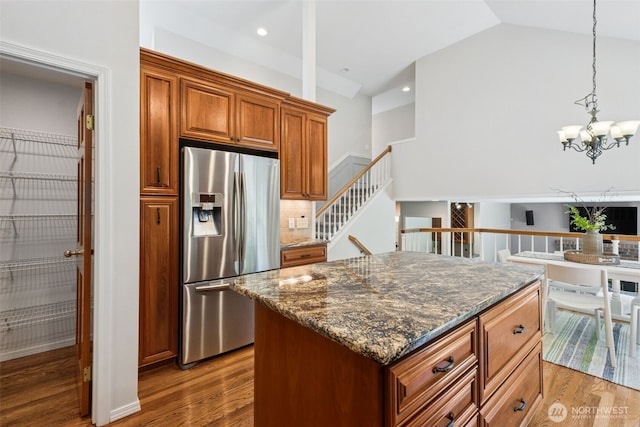28314 180th Ave SE, Covington, WA 98042 - kitchen featuring stainless steel fridge with ice dispenser, wood finished floors, tasteful backsplash, brown cabinets, and lofted ceiling