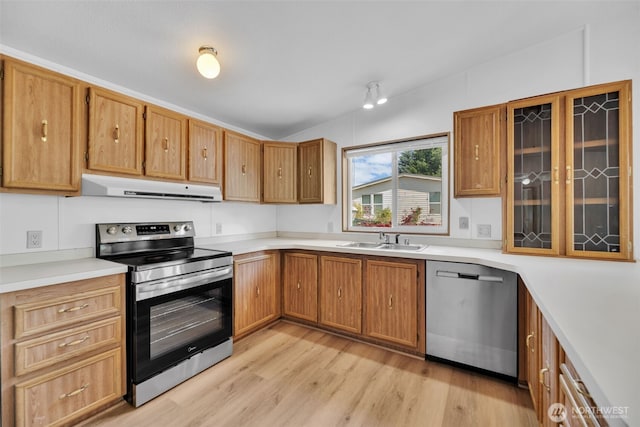 32820 20th Ave S Unit 35, Federal Way, WA 98003 - kitchen with range hood, appliances with stainless steel finishes, light wood finished floors, light countertops, and glass insert cabinets