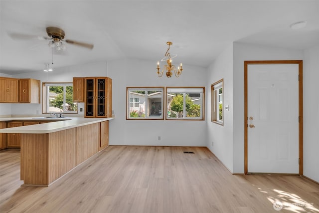 32820 20th Ave S Unit 35, Federal Way, WA 98003 - kitchen featuring a peninsula, light wood-type flooring, vaulted ceiling, glass insert cabinets, and light countertops