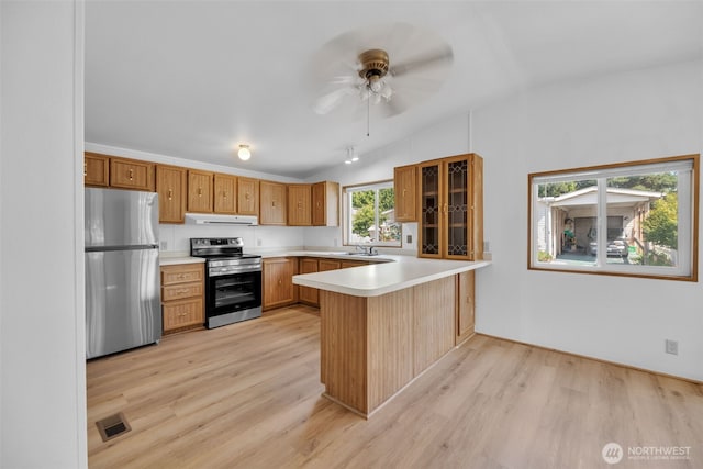 32820 20th Ave S Unit 35, Federal Way, WA 98003 - kitchen with appliances with stainless steel finishes, under cabinet range hood, a peninsula, vaulted ceiling, and light wood-style flooring