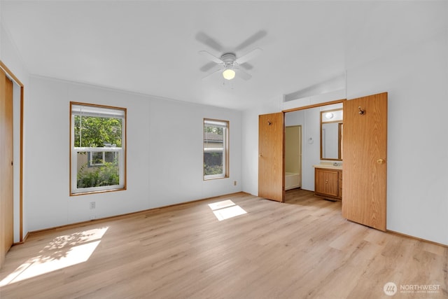 32820 20th Ave S Unit 35, Federal Way, WA 98003 - unfurnished bedroom featuring multiple windows, light wood-style flooring, and ensuite bath