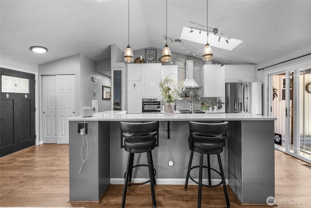 4418 85th Pl SW, Mukilteo, WA 98275 - kitchen with appliances with stainless steel finishes, vaulted ceiling, light countertops, white cabinetry, and a large island