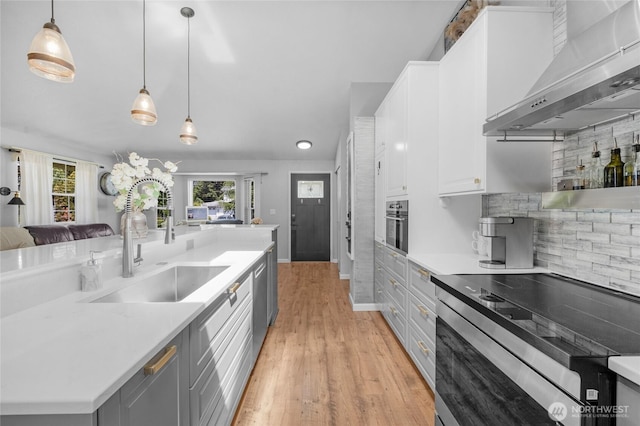 4418 85th Pl SW, Mukilteo, WA 98275 - kitchen featuring stainless steel appliances, wall chimney range hood, light wood-style flooring, gray cabinetry, and white cabinetry