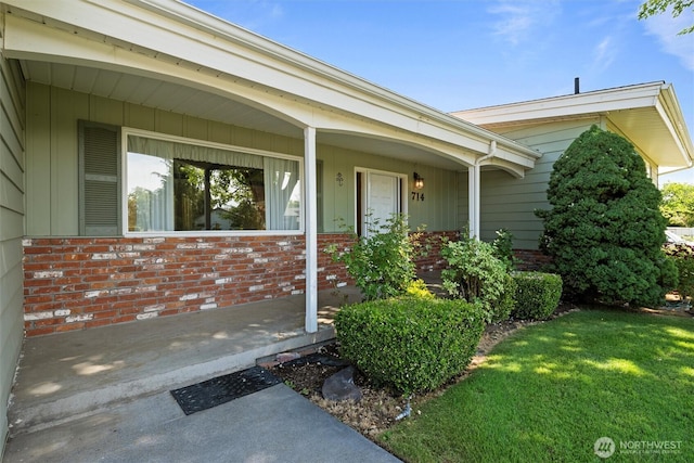 714 Canterbury Rd NW, Soap Lake, WA 98851 - view of exterior entry featuring brick siding, a yard, and covered porch