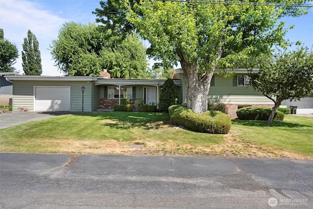 714 Canterbury Rd NW, Soap Lake, WA 98851 - view of front of house featuring an attached garage, driveway, a front lawn, and a chimney