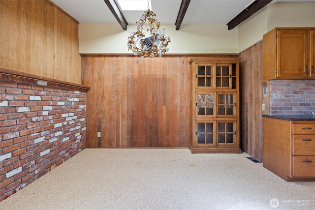 714 Canterbury Rd NW, Soap Lake, WA 98851 - unfurnished dining area featuring wood walls, carpet, beam ceiling, and a chandelier