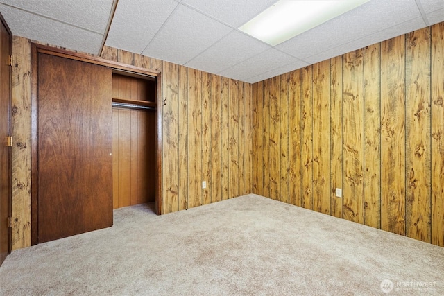 714 Canterbury Rd NW, Soap Lake, WA 98851 - unfurnished bedroom featuring carpet flooring, wooden walls, a closet, and a drop ceiling