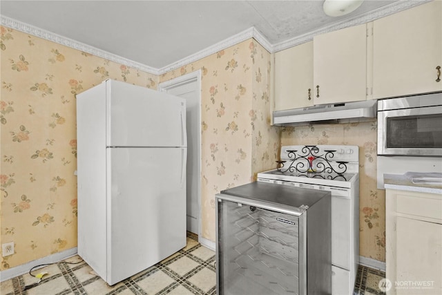 110 3rd Ave SW, Pacific, WA 98047 - kitchen with freestanding refrigerator, under cabinet range hood, wallpapered walls, stainless steel microwave, and stove