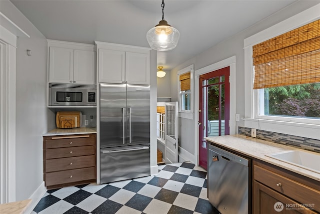 208 N Yakima, Tacoma, WA 98403 - kitchen with built in appliances, light countertops, dark flooring, white cabinets, and decorative backsplash
