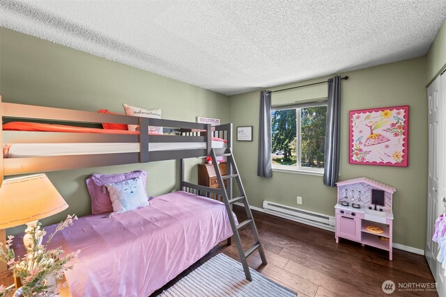 6105 N 16th St Unit N203, Tacoma, WA 98406 - bedroom with a baseboard radiator, hardwood / wood-style flooring, and a textured ceiling
