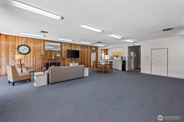 6105 N 16th St Unit N203, Tacoma, WA 98406 - living area featuring wooden walls, a textured ceiling, dark colored carpet, and a fireplace