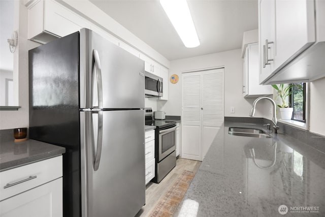 145 7th St, Gold Bar, WA 98251 - kitchen with appliances with stainless steel finishes, white cabinets, dark stone counters, and light wood-style flooring