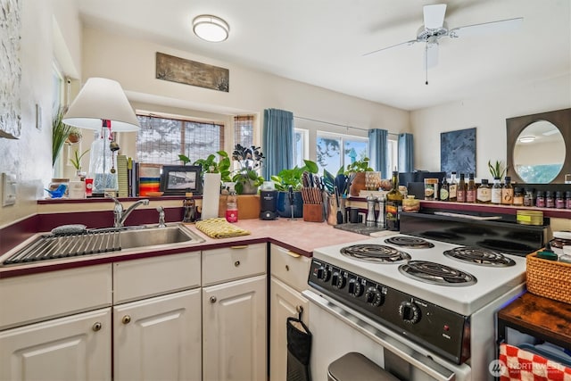 10125 Totem Way, Anderson Island, WA 98303 - kitchen with white electric range, white cabinetry, ceiling fan, and light countertops