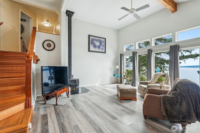 10125 Totem Way, Anderson Island, WA 98303 - living room with a wood stove, healthy amount of natural light, ceiling fan, wood finished floors, and a high ceiling