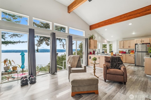 10125 Totem Way, Anderson Island, WA 98303 - living area featuring beam ceiling, high vaulted ceiling, light wood finished floors, recessed lighting, and a water view