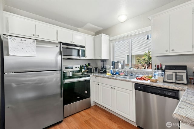 10421 19th Ave SE, Everett, WA 98208 - kitchen featuring appliances with stainless steel finishes, white cabinetry, light wood-type flooring, and light countertops