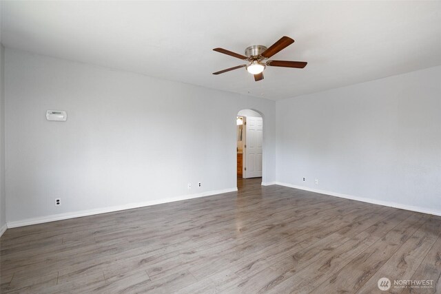 5030 S Park Ave S, Tacoma, WA 98408 - unfurnished room with arched walkways, ceiling fan, and wood finished floors