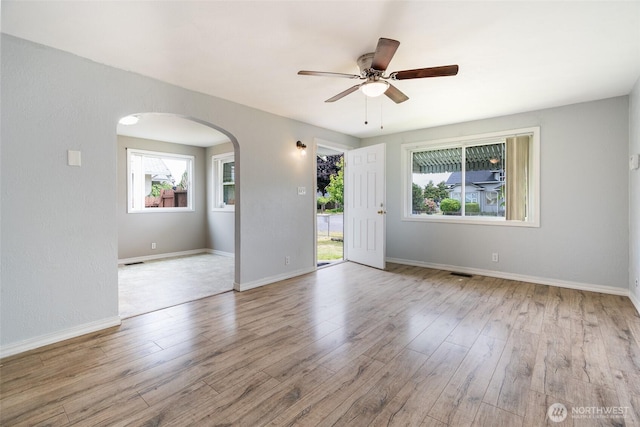 5030 S Park Ave S, Tacoma, WA 98408 - empty room featuring arched walkways, healthy amount of natural light, and wood finished floors