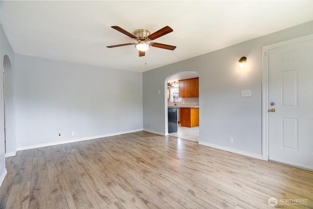 5030 S Park Ave S, Tacoma, WA 98408 - empty room featuring arched walkways, ceiling fan, and light wood-style floors