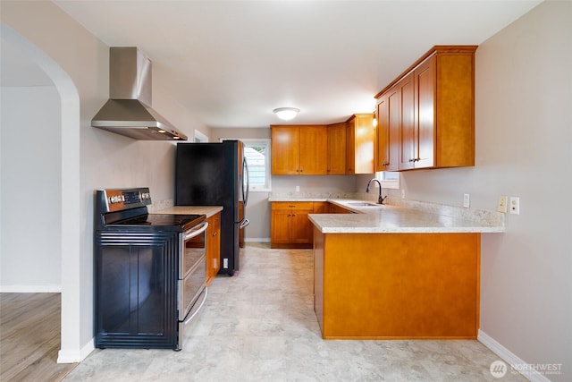 5030 S Park Ave S, Tacoma, WA 98408 - kitchen with wall chimney range hood, stainless steel appliances, brown cabinetry, and a peninsula
