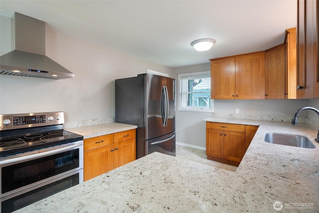 5030 S Park Ave S, Tacoma, WA 98408 - kitchen with wall chimney exhaust hood, appliances with stainless steel finishes, light stone countertops, and brown cabinetry