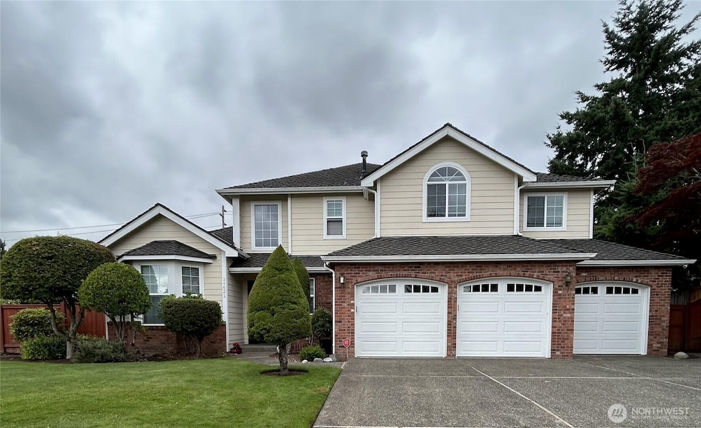 34621 11th Ct SW, Federal Way, WA 98023 - traditional home featuring an attached garage, driveway, brick siding, and a shingled roof