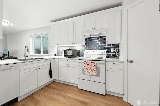 3806 Wetmore Ave, Everett, WA 98201 - kitchen with white appliances, under cabinet range hood, backsplash, light wood-style flooring, and white cabinetry