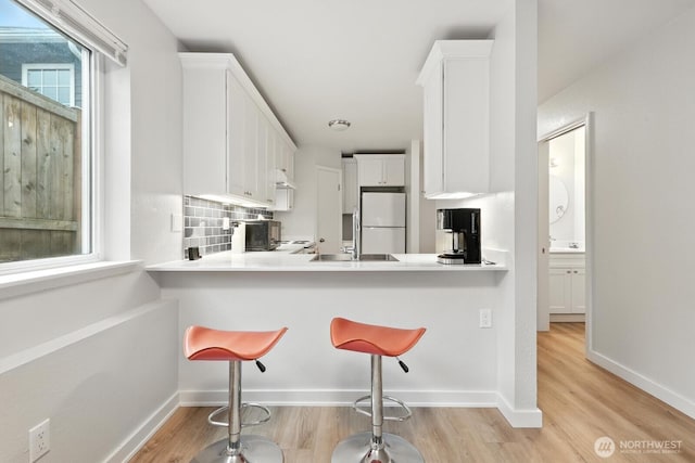 3806 Wetmore Ave, Everett, WA 98201 - kitchen featuring freestanding refrigerator, light wood-style floors, light countertops, and white cabinets